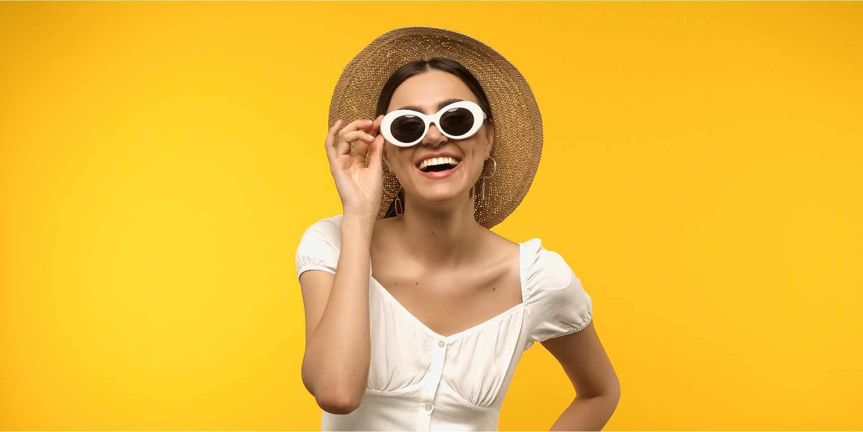 happy woman wearing shades and ear hoops